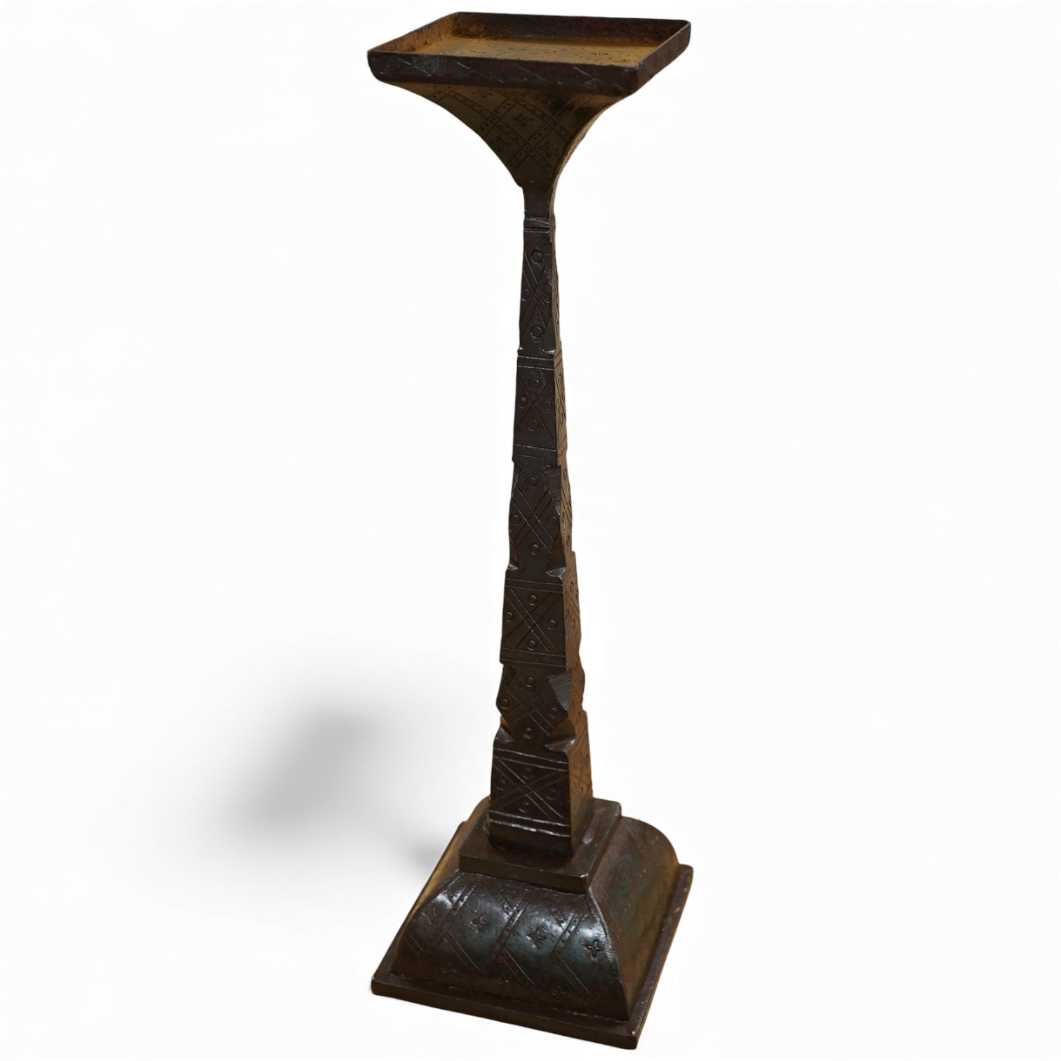 An iron candle stick with incised geometric decoration, 49cm high